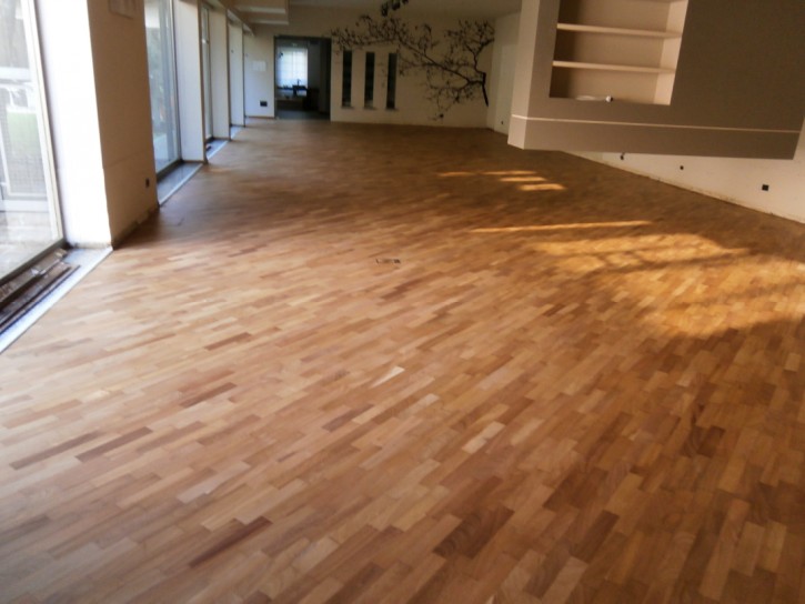 Sanding and repainting of the flooring in the showroom Sanding and new painting of the wooden flooring in a high-end furniture showroom