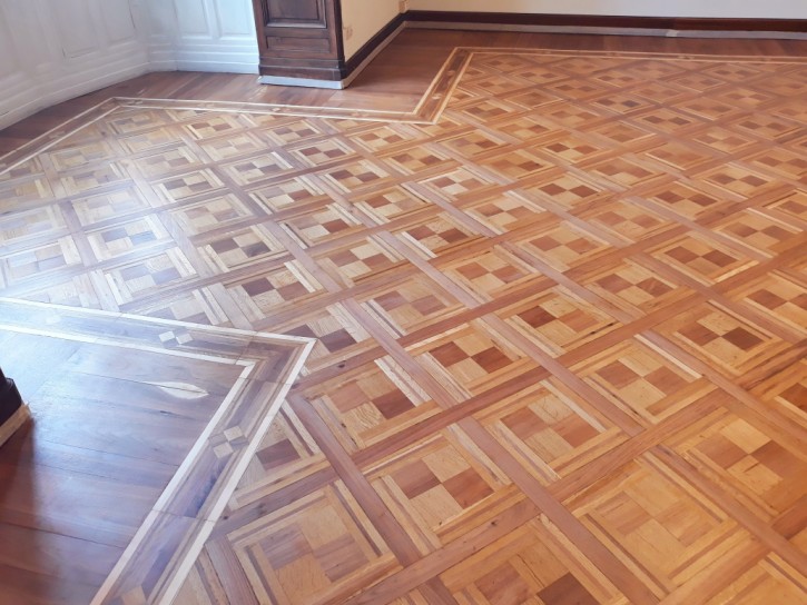 Sanding and repainting of vintage parquet Light sanding to remove worn-out old paint and application of a new finish with wax-effect paint